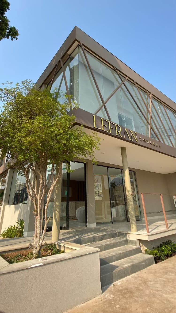 Fachada de vidro do Lefran Concept com a treliça de metal e o letreiro dourado sobre a entrada